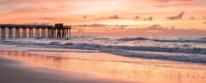 Where in the World 667 pier, waves and shoreline at sunset