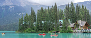 Where in the World 679 canoeist on a lake with forest and mountains