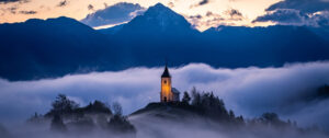 Where in the World 717 featured image church in mountains above mist in valley