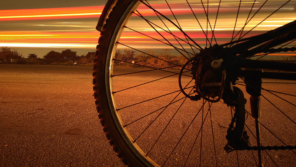 cycling book review bicycle wheel and sunset